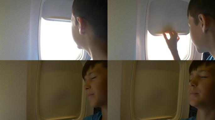 男孩关闭飞机上的舷窗并准备睡觉