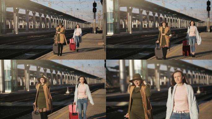 火车站的两个女孩带着行李箱在站台上等着火车。