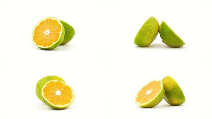 绿色橘子水果的两半，带有水滴。在转盘上旋转。孤立在白色背景上。特写。宏观。