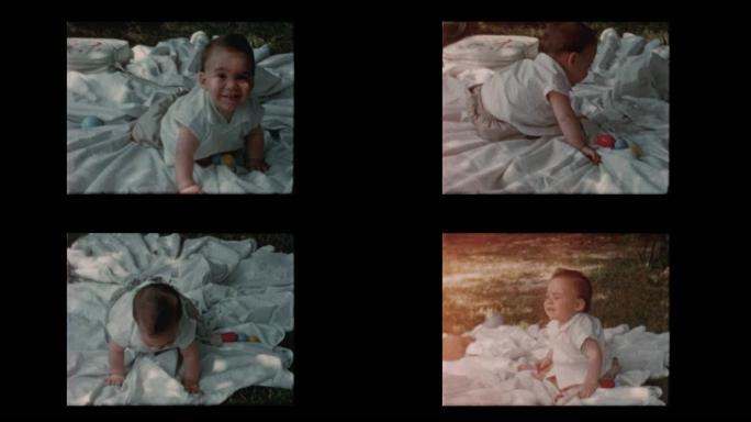 1960快乐的男婴爬着坐在外面的毯子上