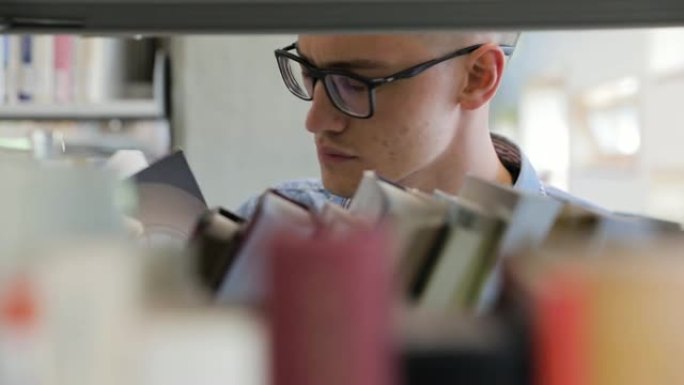 男子在大学图书馆的书架上寻找书