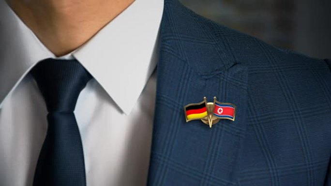 商人拿着朋友的国旗走向相机，胸针是德国-朝鲜
