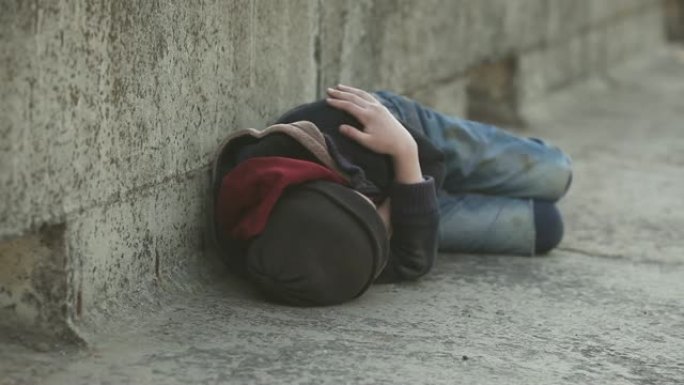 年轻的无家可归的男孩睡在桥上