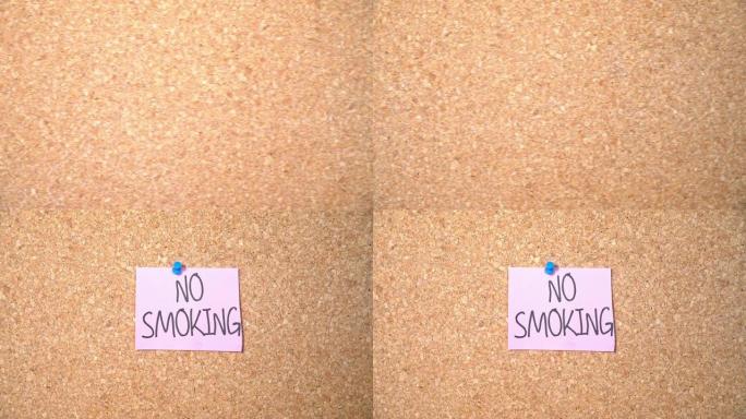 一名男子钉在软木板上的纸上禁止吸烟单词组