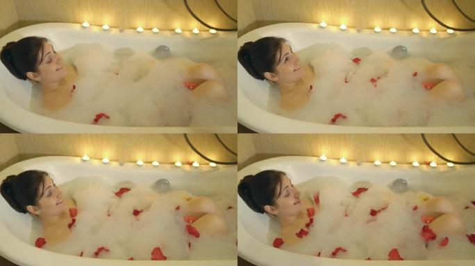 一个黑发女人正在用泡沫和玫瑰花瓣洗澡