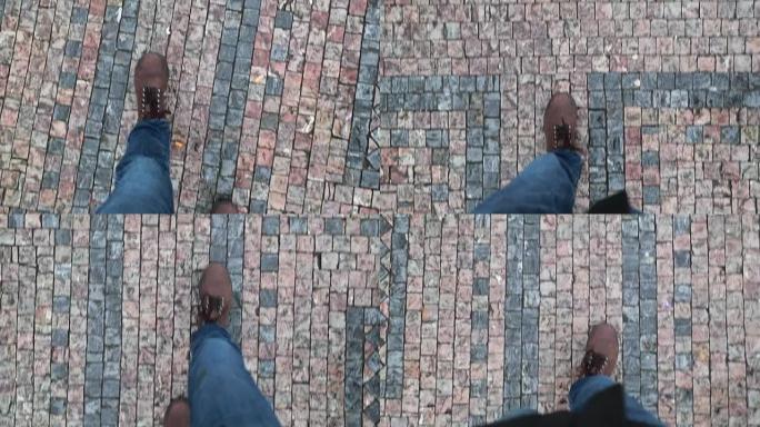 穿着靴子走在鹅卵石中世纪地面上的人的视点。行人脚走路的观点。
