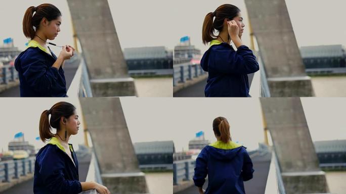 慢动作 -- 泰国曼谷日落之前，年轻的亚洲女子在桥上奔跑。女性慢跑者训练户外概念，女孩在智能手机上听