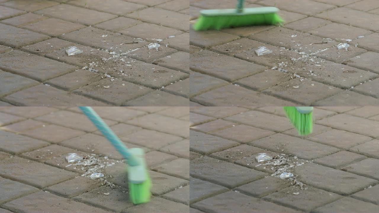 用扫帚清洁地板上的碎玻璃