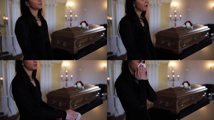 在教堂的葬礼上用擦拭和棺材的女人