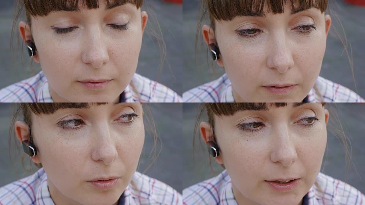 迷人的白人妇女在户外通过无线耳机通话的特写镜头。