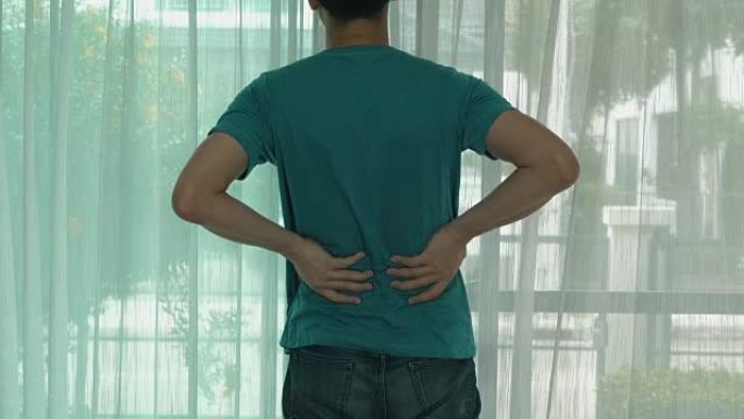 男人从背部疼痛的感觉中伸展身体