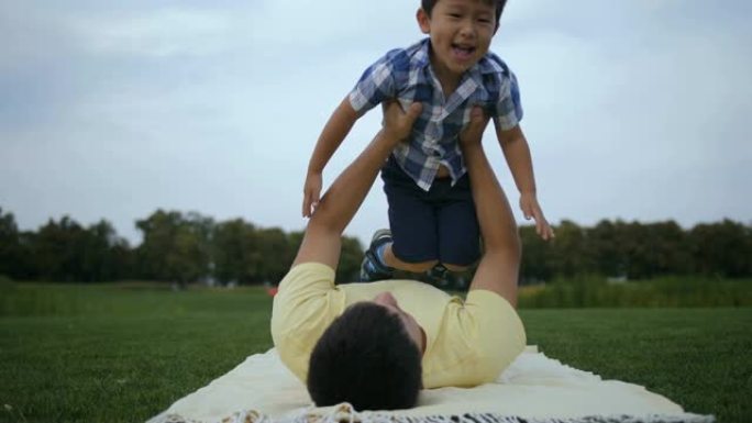 慈爱的父亲和他可爱的亚洲儿子一起玩