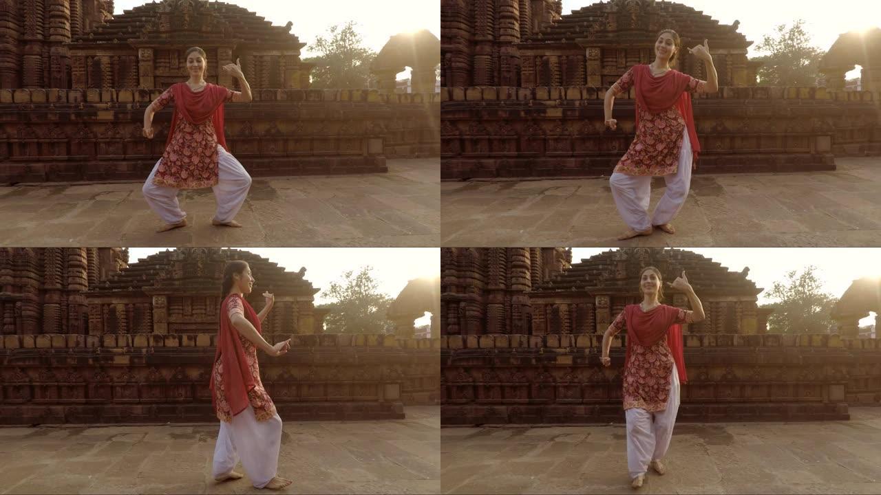 年轻的印度妇女在古庙前跳舞传统的奥迪西风格