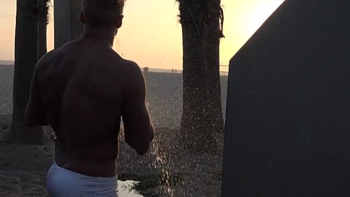 性感的肌肉男人在海滩上洗澡