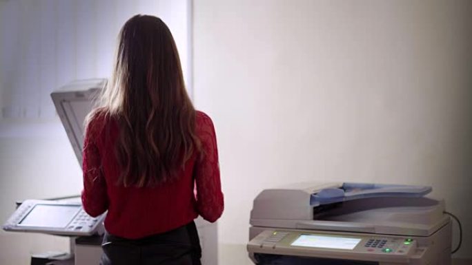 激光机背景下的黑发上班族。妇女使用打印机复印文件