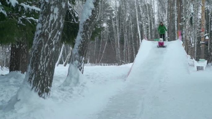 小女孩从大冰滑梯上骑行