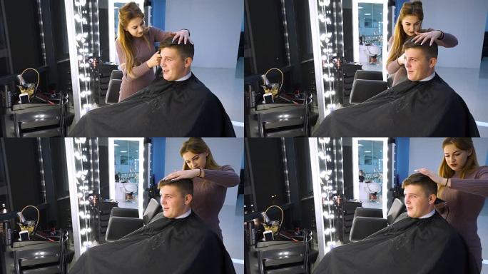 美容院里的一个年轻帅哥。那家伙正坐在扶手椅上。理发师给她理发。那家伙坐在镜子前。他很高兴。
