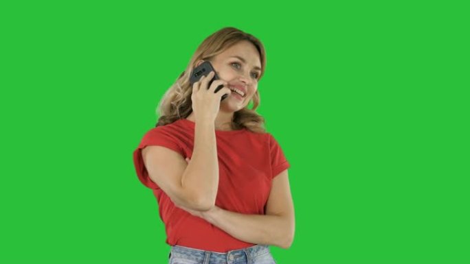 穿着红色t恤的年轻美女在绿屏上在手机上讲话，色键