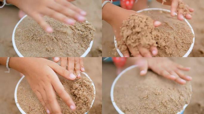 小女孩用塑料桶舀沙子，然后受到打击