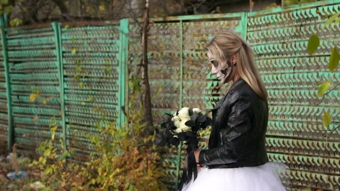 令人毛骨悚然的新娘，带着一束黑花和头骨形式的化妆
