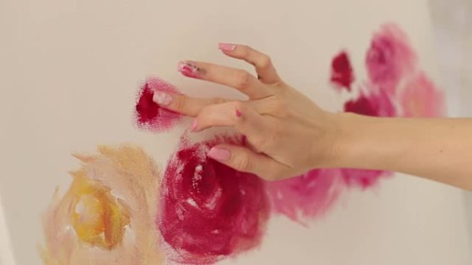 女人在画布上画了一根手指，特写。