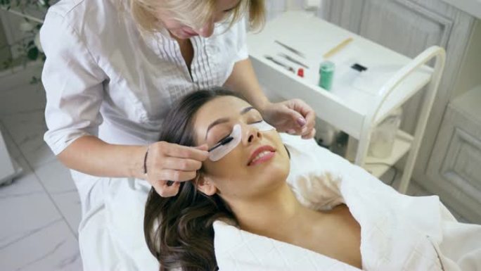 睫毛延伸程序，在美容院为女性客户梳理睫毛的大师