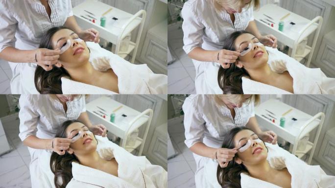 睫毛延伸程序，在美容院为女性客户梳理睫毛的大师