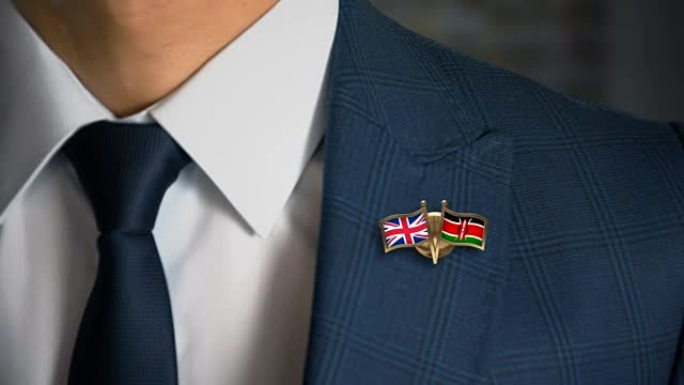 商人走向相机，带着朋友国家的国旗别针英国-肯尼亚