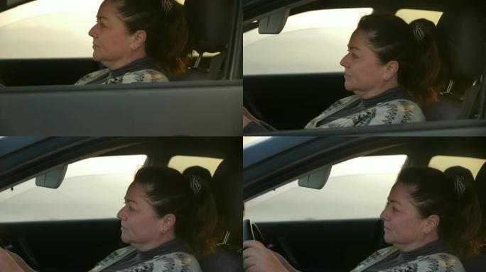 一名妇女驾驶着一辆车，从后视镜中可以看到山景