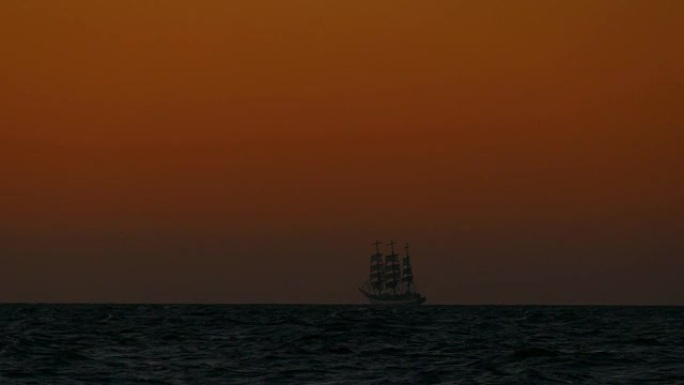 旅行背景-日落时航行中的老式高船