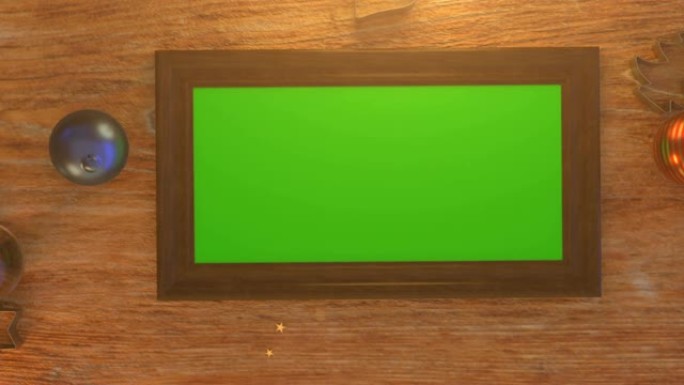 带圣诞装饰的木桌上绿屏相框的俯视图