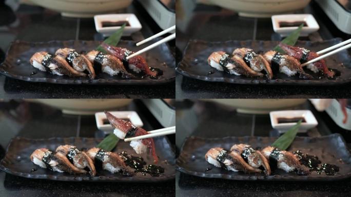 手持筷子拿Unagi寿司的前视图