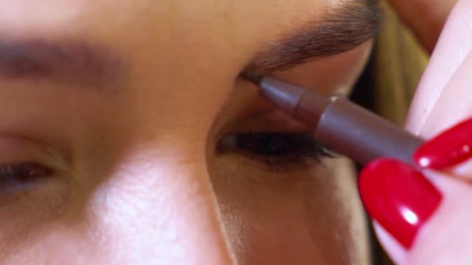 女性化妆师的特写镜头在美容院为女性模特做眉毛形状校正