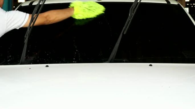 手的男人用绿色海绵洗车