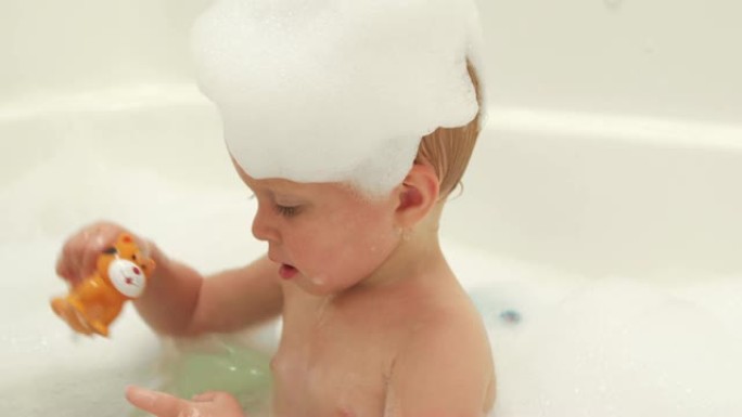 一个婴儿洗泡泡浴，玩挤压玩具