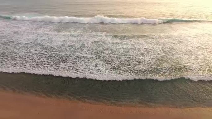 日落时在热带海滩上破裂的海浪的扩展轨道拍摄