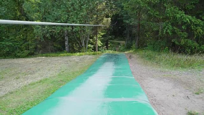 冒险公园上有长绳的绿色滑梯