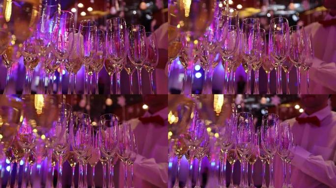 服务员在酒杯中倒香槟，在餐厅的桌子上倒香槟，在节日的桌子上倒香槟，在酒保为香槟准备的桌子上倒干净的玻