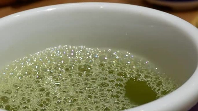 日本餐厅内餐桌上热绿茶的运动