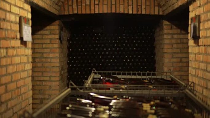 古代葡萄酒意大利酒窖。酒窖内的架子上和金属篮中没有标签的酒瓶。黄光照在地窖里。4K (UHD