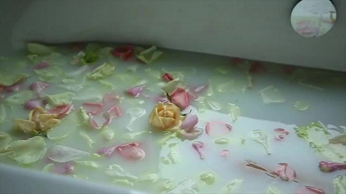 带着花瓣的白色浴缸里的女孩