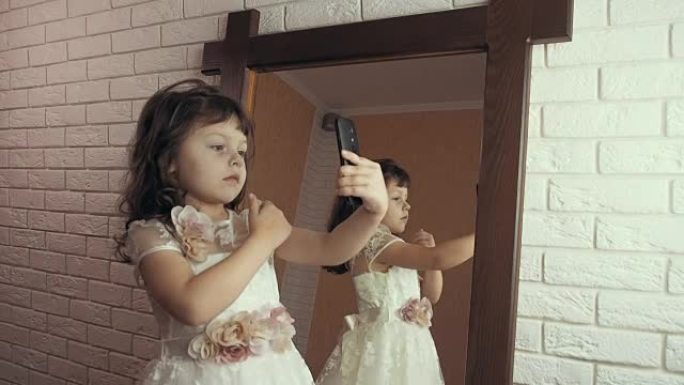 一个孩子在镜子前拿着电话