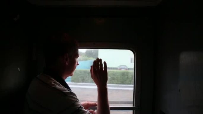 一个人看着窗外的汽车在铁路上。