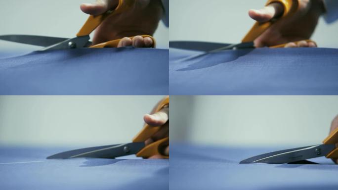 男人用橙色剪刀切割蓝色材料