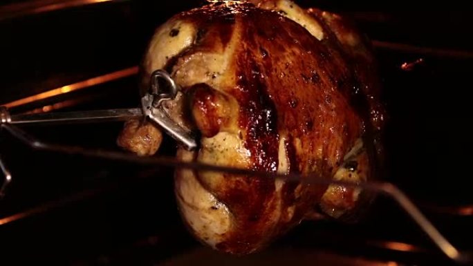 用烤炉在烤肉店吐出烤鸡。烤鸡在烧烤元件下旋转。内部视图。
