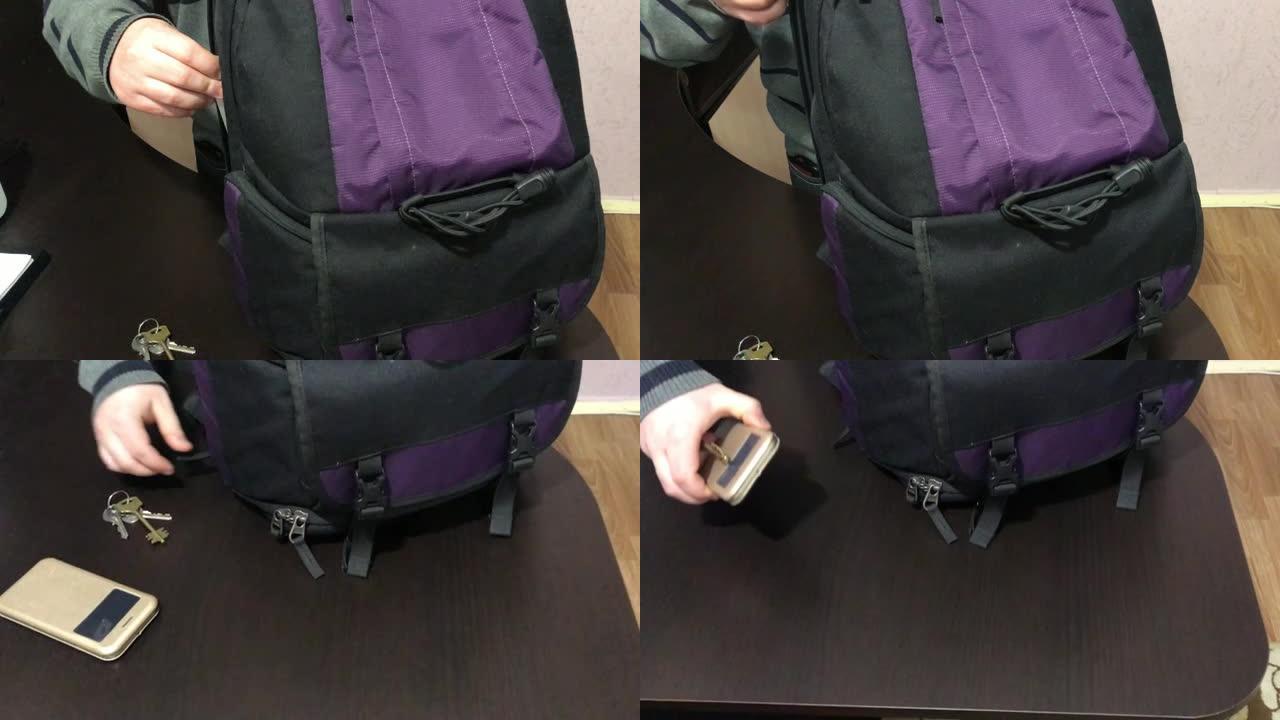 一个年轻人把笔记本电脑放在背包里。他拿起桌子上的钥匙，电话就走了。