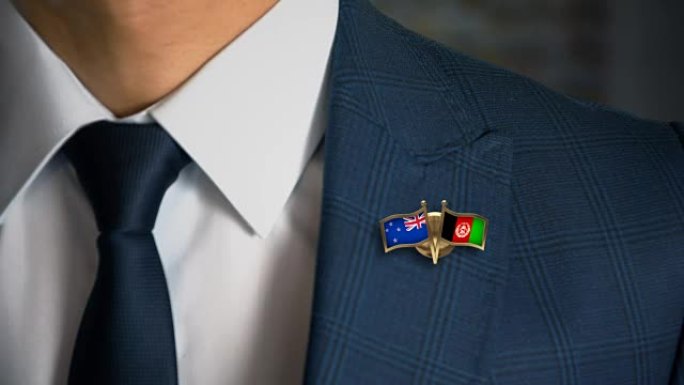 商人带着朋友国家的国旗走向相机钉新西兰-阿富汗
