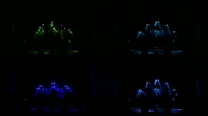 蓝色和紫色的光闪烁和白色的光线在黑暗中的空舞台上。