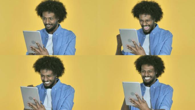 非洲裔美国人在黄色背景上使用平板电脑时对成功感到兴奋