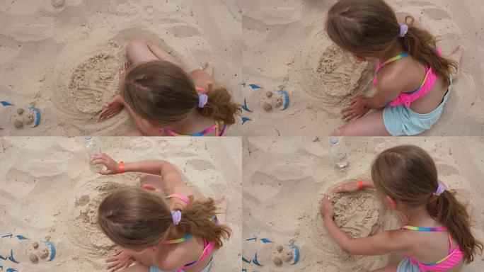 女孩少年在夏日海滩上做沙质蛋糕